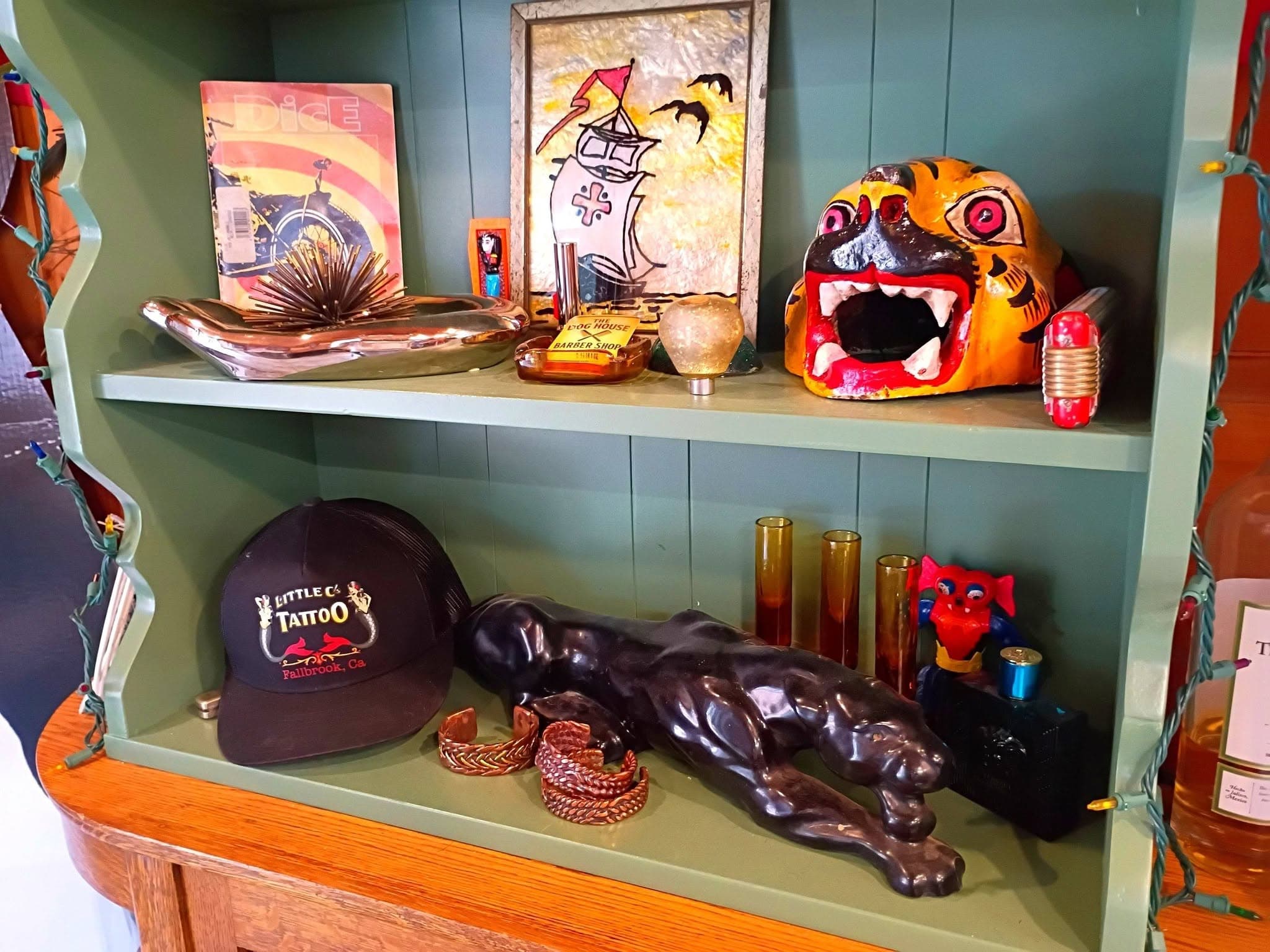 Vintage tattoo-themed artwork and tiger figurine display