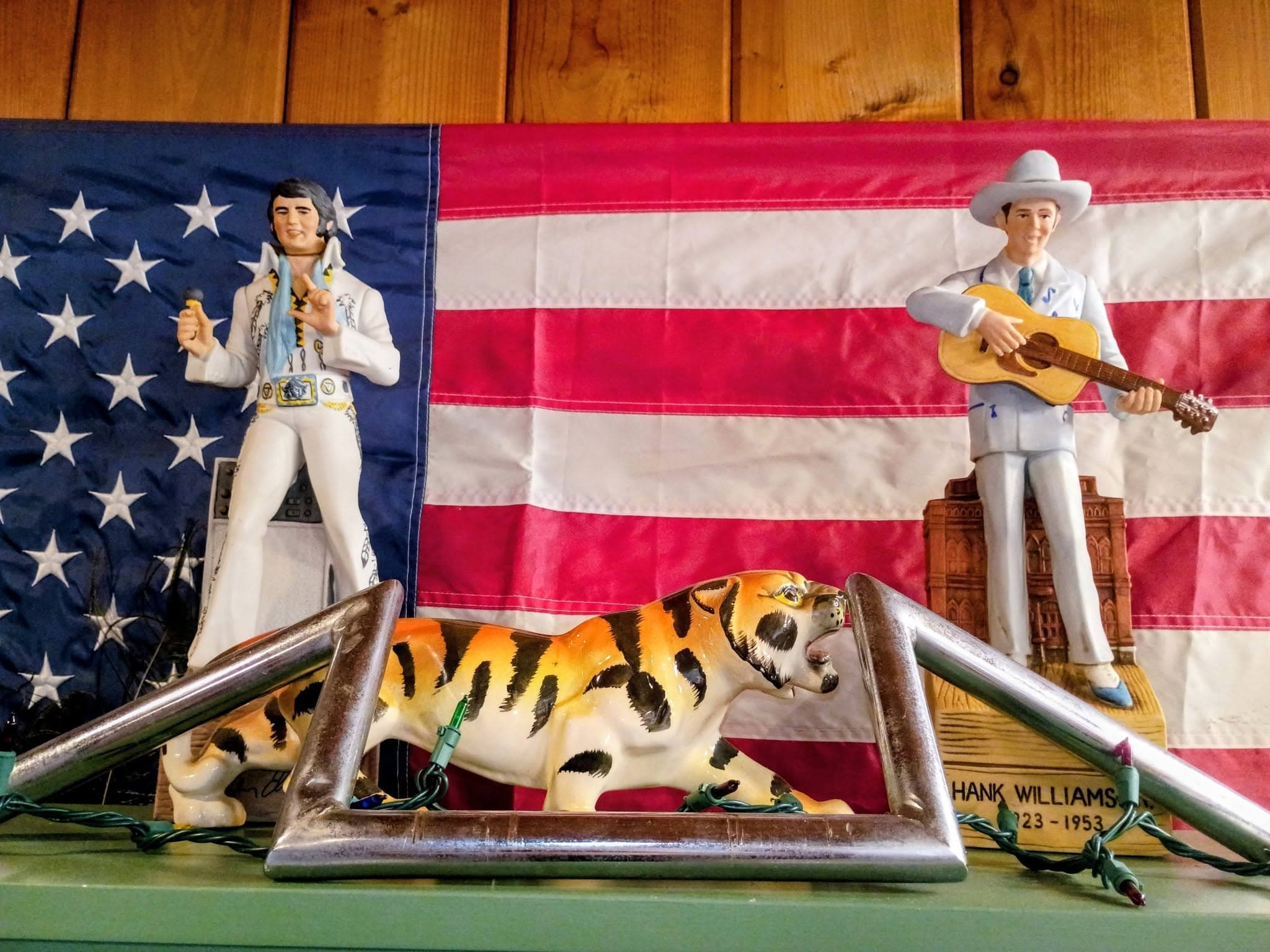 Elvis and cowboy figurines with American flag backdrop