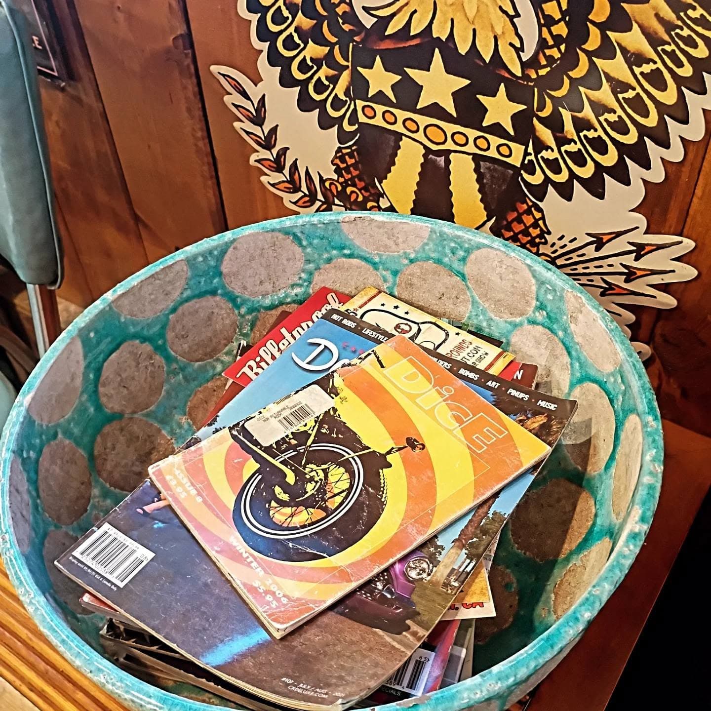 Vintage motorcycle and car magazines in turquoise basket