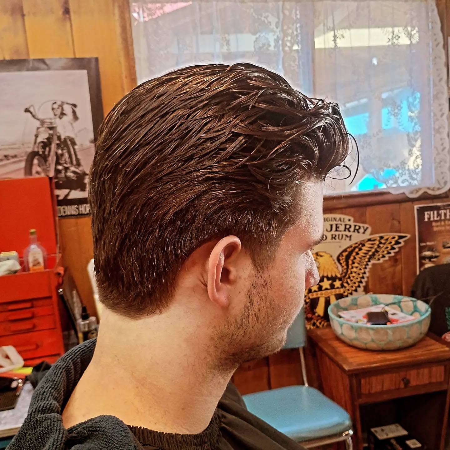Finished hairstyle showing voluminous dark hair with fade