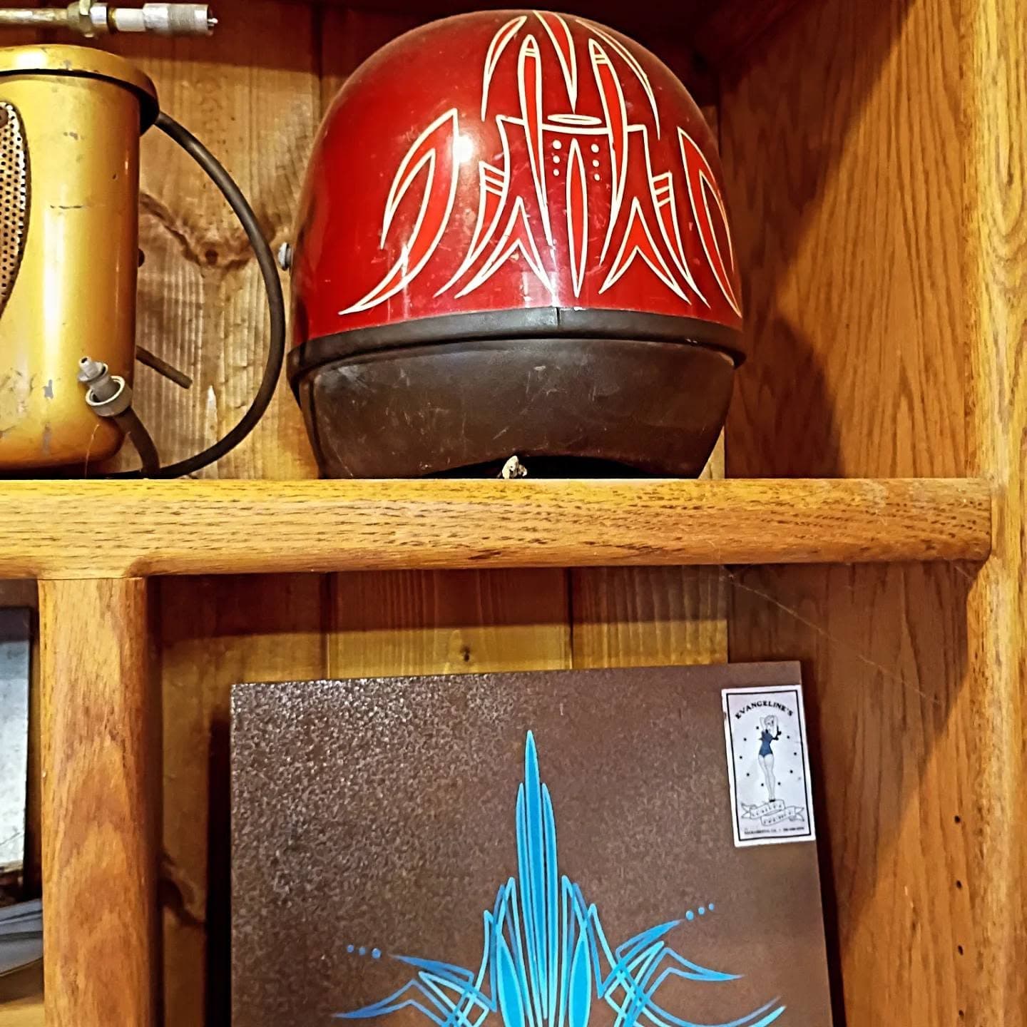 Red motorcycle helmet with flame design on shelf
