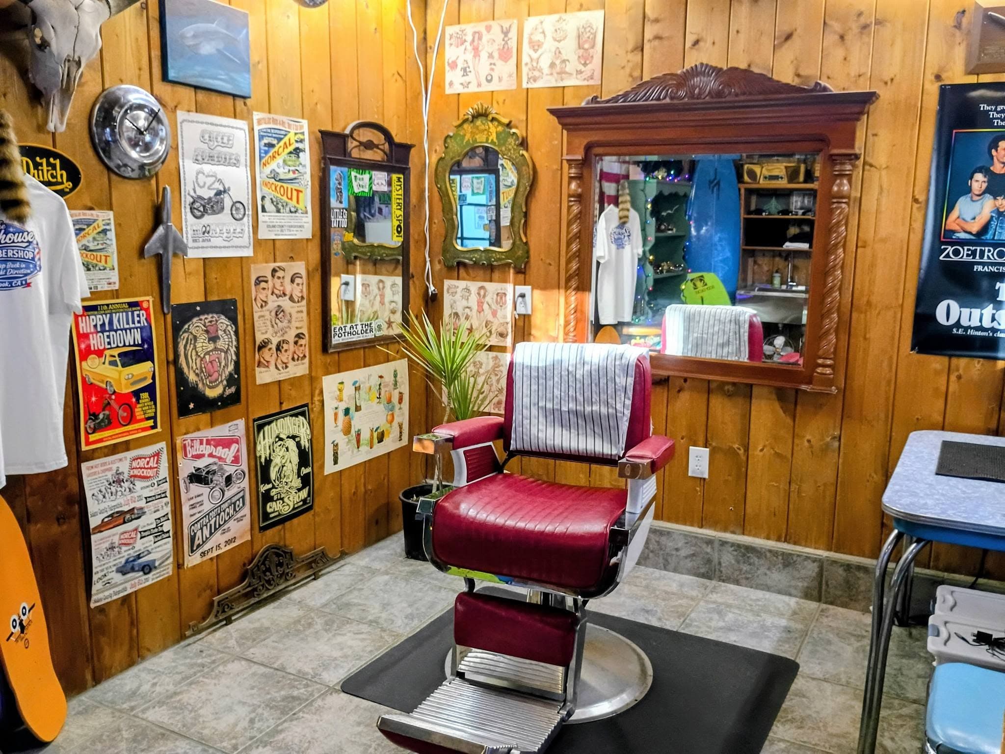 Wide shop interior with red barber chair, vintage signs, and memorabilia